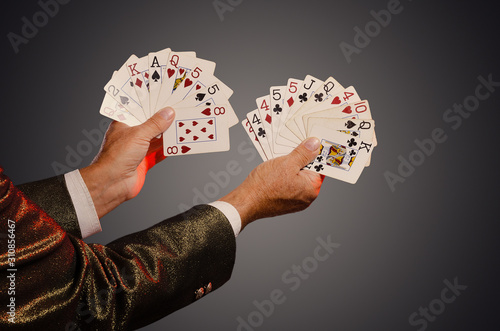 Magician shows trick with playing cards. Sleight of hand. Manipulation with props.
