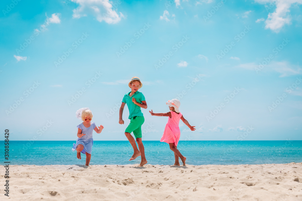happy kids- boy and girls- dance at beach, family enjoy vacation at sea