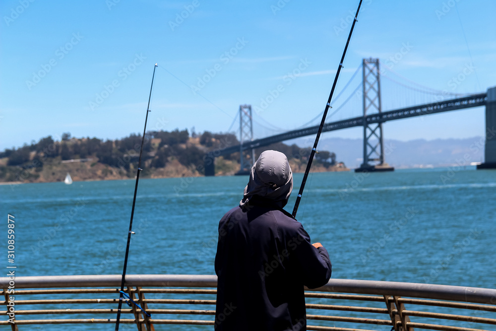 Fisherman with fishing rods near the White Bridge between San Francisco and Auckland in California