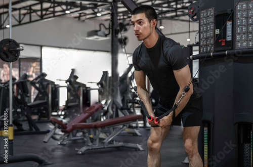 Fotografija athletic man doing chest exercise using cable crossover machine gym sports fitne