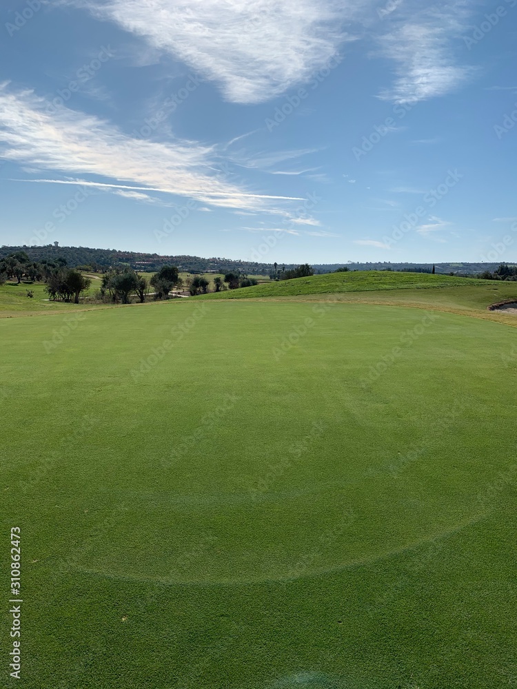 golf green with bunker and fairway in view golf green with bunker and fairway in view