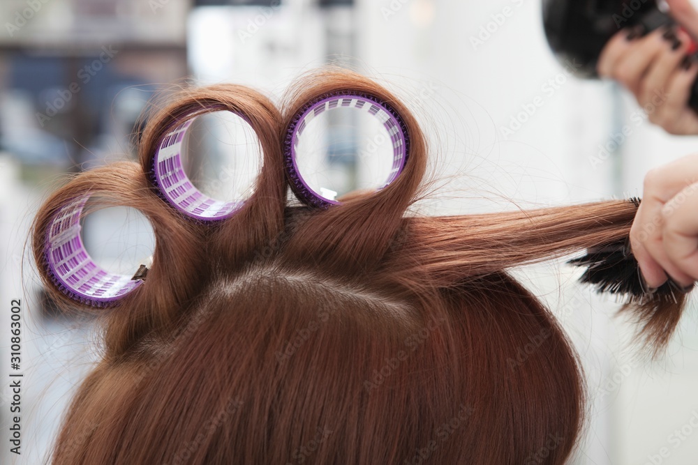 Fototapeta premium Hairdresser Rolling Up Curlers For Client