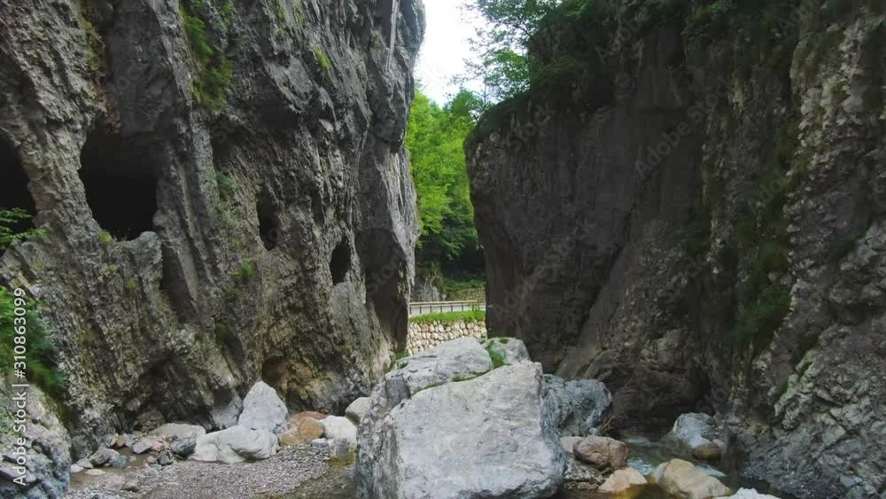 Cove between the rocks and shallow river flows between them and exits directly into the traffic road Cove between the rocks and shallow river flows between them and exits directly into the traffic road