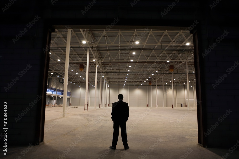 Businessman Standing At Warehouse Entrance Businessman Standing At Warehouse Entrance