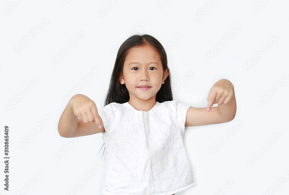 Smiling little Asian child girl pointing down to present something isolated over white background. Asian schoolgirl in education concept. Smiling little Asian child girl pointing down to present something isolated over white background. Asian schoolgirl in education concept.