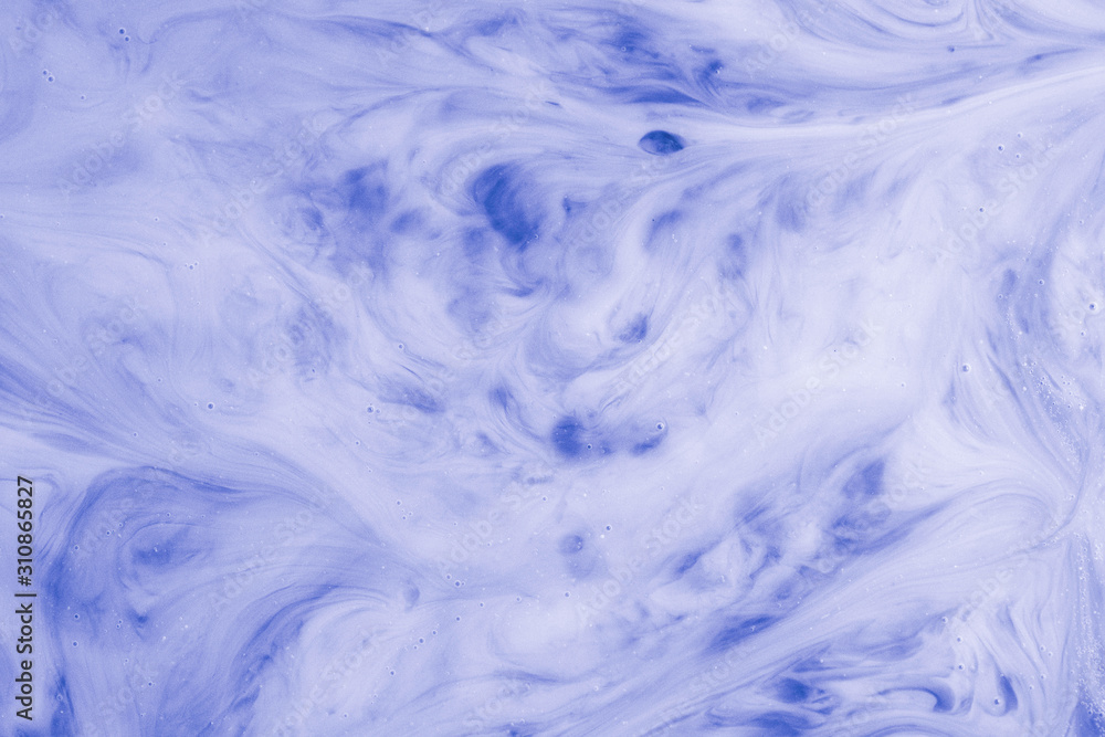 Obraz premium A macro photo of drops of blue food dye swirled and mixed into thick creamy white milk to give a marbled milkshake effect