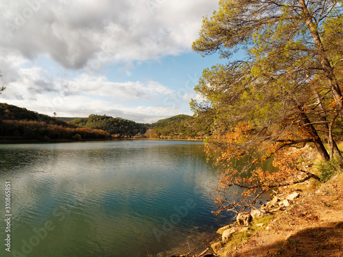 Lac de Carc  s ou Sainte Suzanne en Provence verte. Sentier de randonn  e autour du lac  bord   de hauts arbres et v  g  tation de garrigue aux couleurs d automne