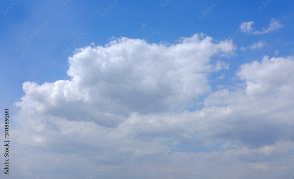 Blue sky and fluffy clouds background.