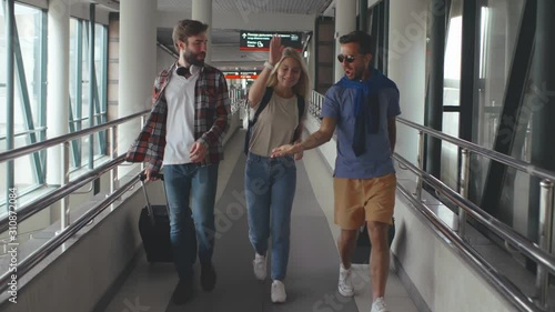 Cheerful friends go on a trip and walking to the airport