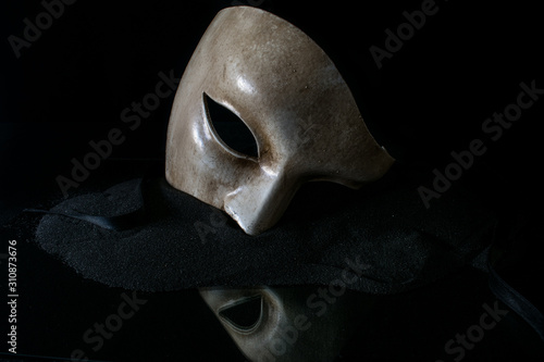 Opera mask on the black sand