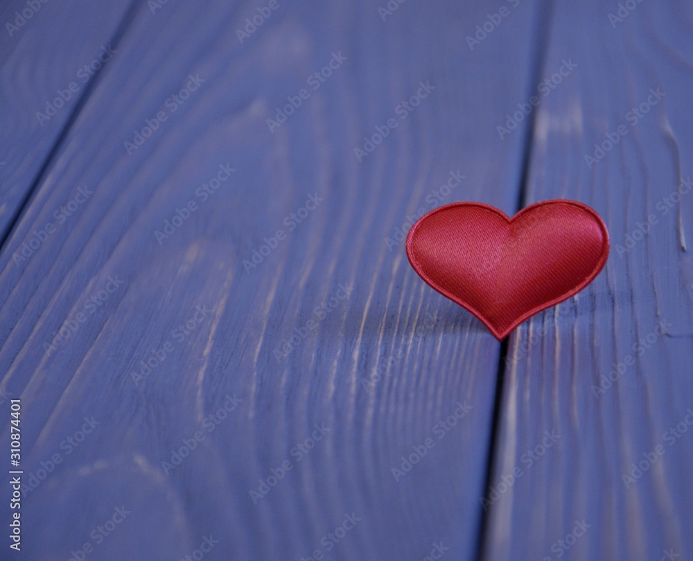 Fototapeta premium Valentine's Day, red satin heart on a wooden background.