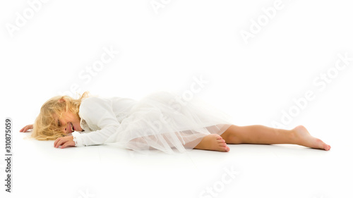 Little girl lies on the floor.Studio photo shoot on a white back