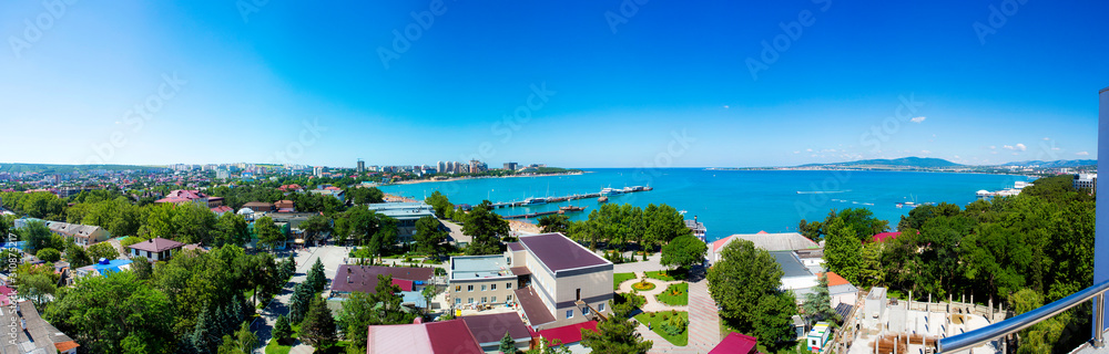Panorama of the resort of Gelendzhik, the Black sea. Gelendzhik Bay. sea pier with standing pleasure ships and yachts. In the background  promenade with balustrades and lanterns