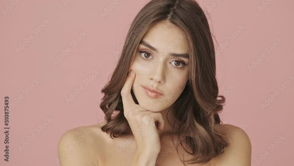 A bored dissatisfied half-naked woman is looking to the side isolated over pink background A bored dissatisfied half-naked woman is looking to the side isolated over pink background