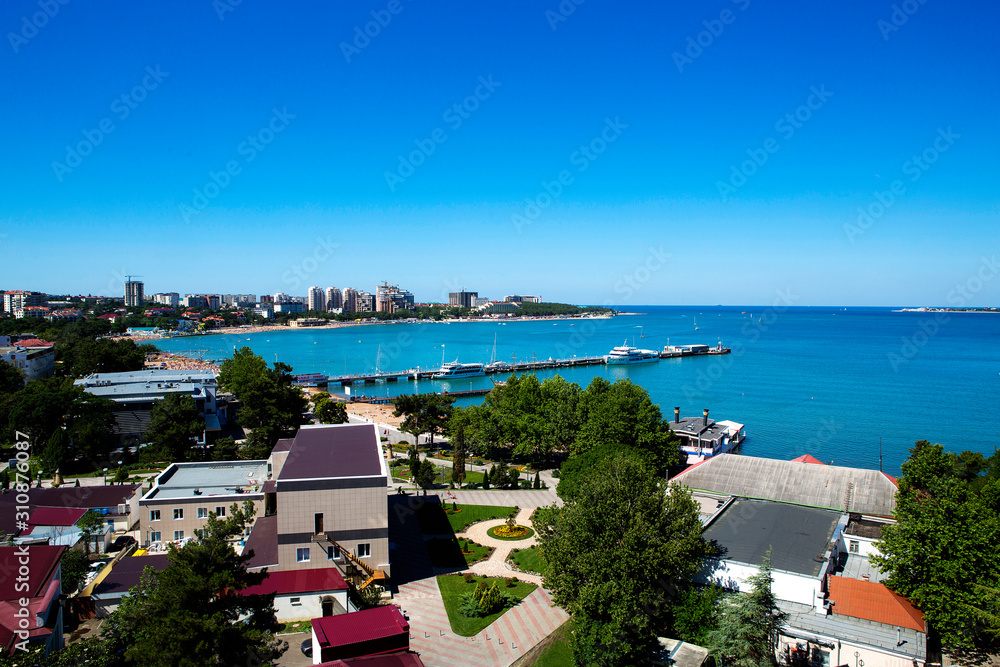 Panorama of the resort of Gelendzhik, the Black sea. Gelendzhik Bay. sea pier with standing pleasure ships and yachts. In the background  promenade with balustrades and lanterns