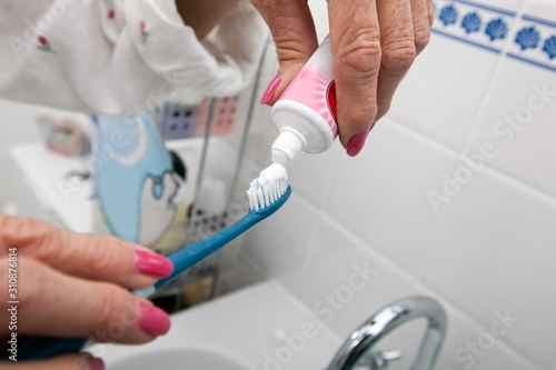 Cropped image of senior woman putting tooth paste on brush at home © moodboard