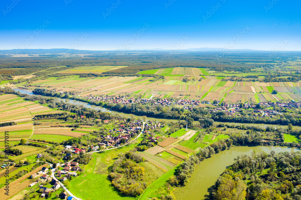 Obraz premium Beautiful countryside landscape in Croatia, near Sisak, Sava river meandering between agriculture fields, aerial shot from drone