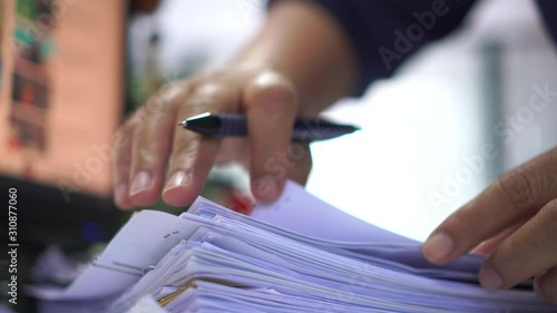 Businessman hands working in stacks of paper files for searching information on work desk office, business report papers,piles of unfinished documents achieves with clips indoor,Business concept