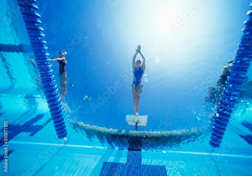 View of female swimmer diving in swimming pool