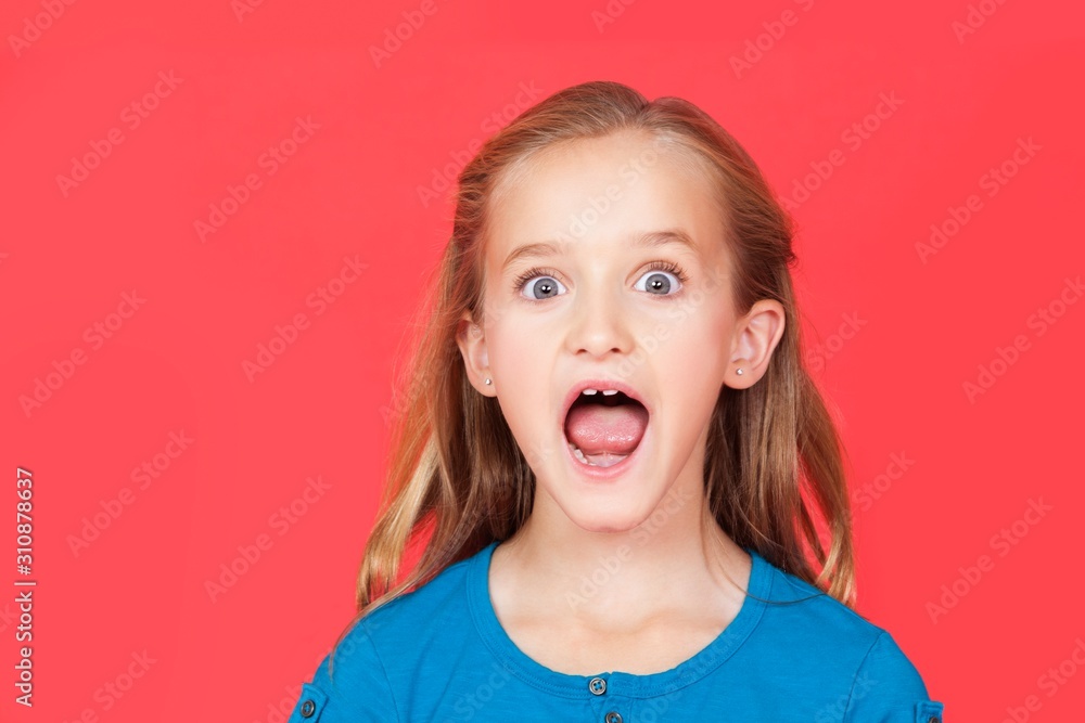 Portrait of shocked young girl with mouth open against red background Portrait of shocked young girl with mouth open against red background