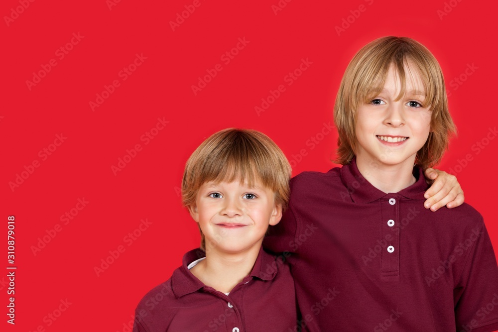 Portrait of two happy brothers against red background Portrait of two happy brothers against red background