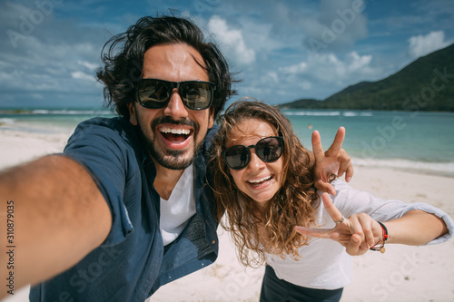 A pair of lovers take a selfie on a tropical beach. photo