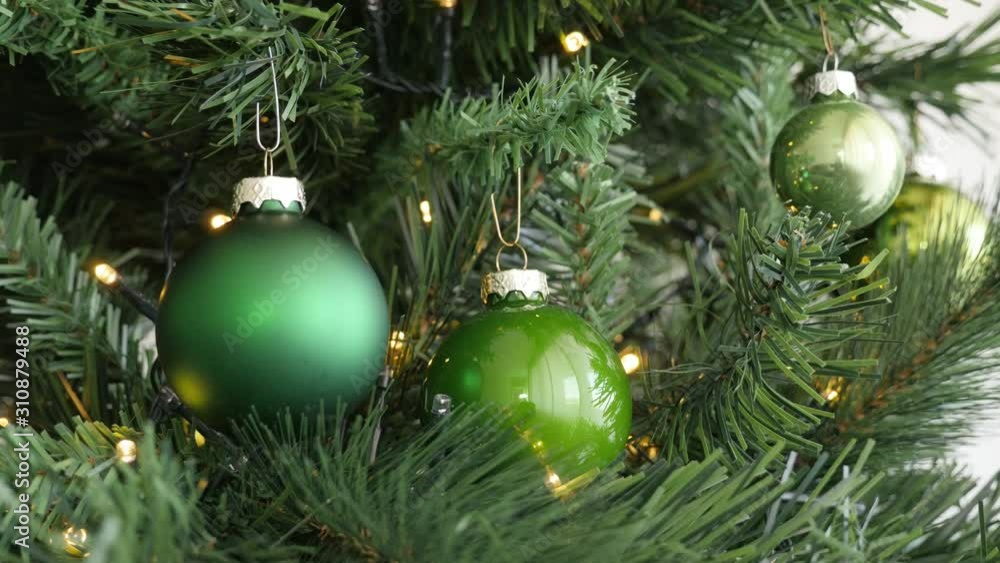 Assorted green baubles on Christmas tree with fairy lights 4K video Assorted green baubles on Christmas tree with fairy lights 4K video