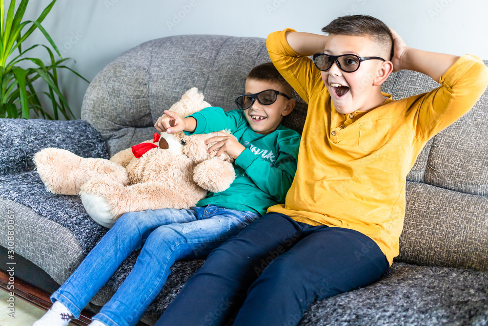 Cute boys watching scary movie with 3d glasses, together with teddy bear toy Cute boys watching scary movie with 3d glasses, together with teddy bear toy