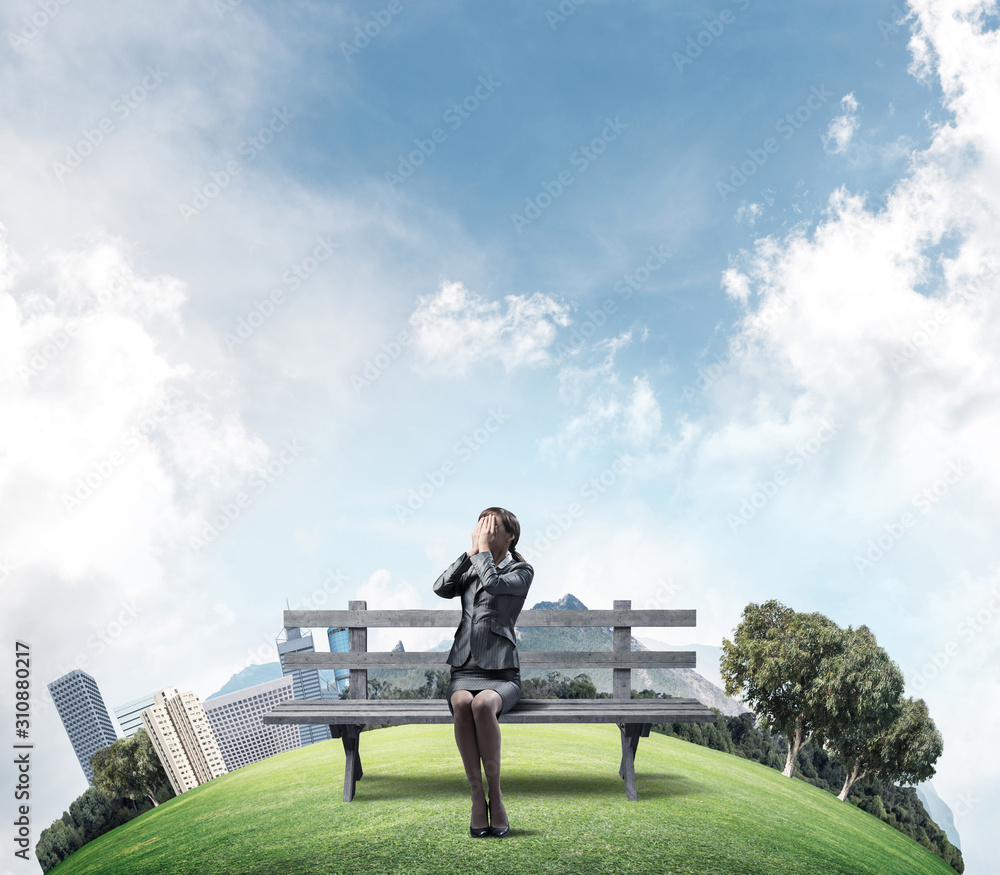 Young woman sitting on wooden bench outdoors Young woman sitting on wooden bench outdoors