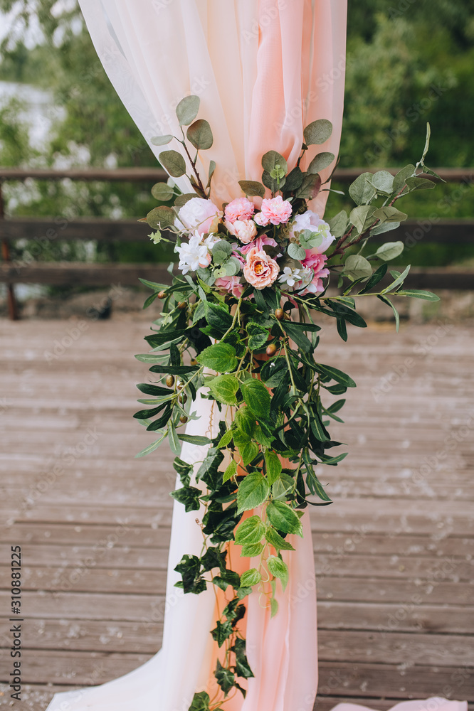 Wedding arch closeup of fresh flowers and fabric on nature background ...