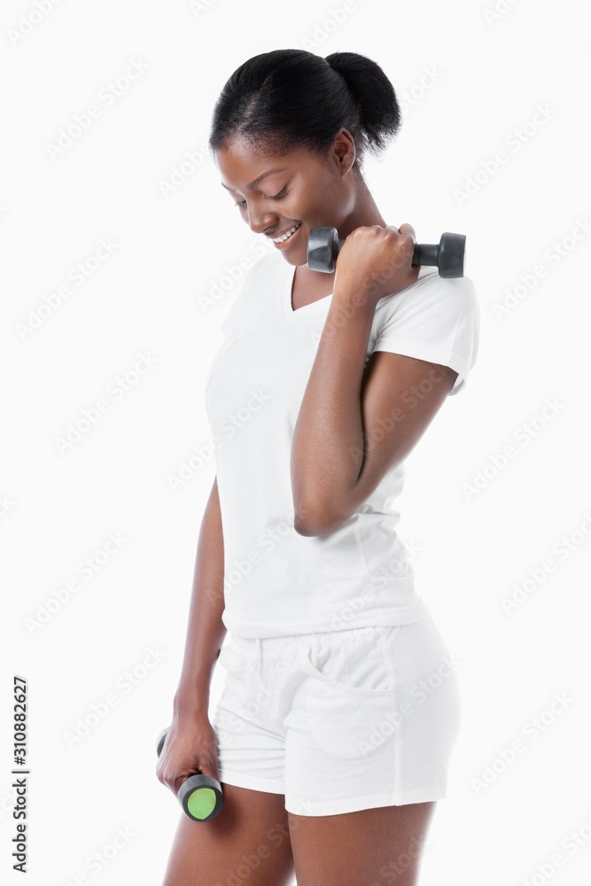 Thoughtful African American young woman with dumbbells standing over white background Thoughtful African American young woman with dumbbells standing over white background