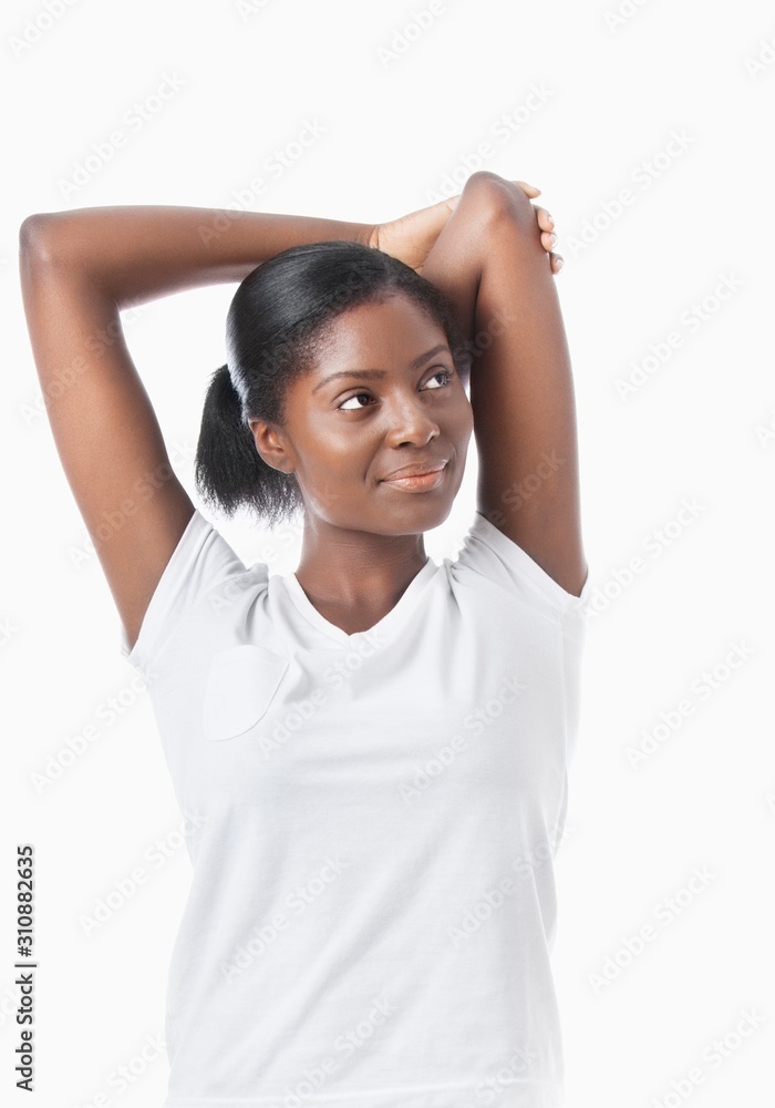 African American young woman with arms raised looking away over white background African American young woman with arms raised looking away over white background