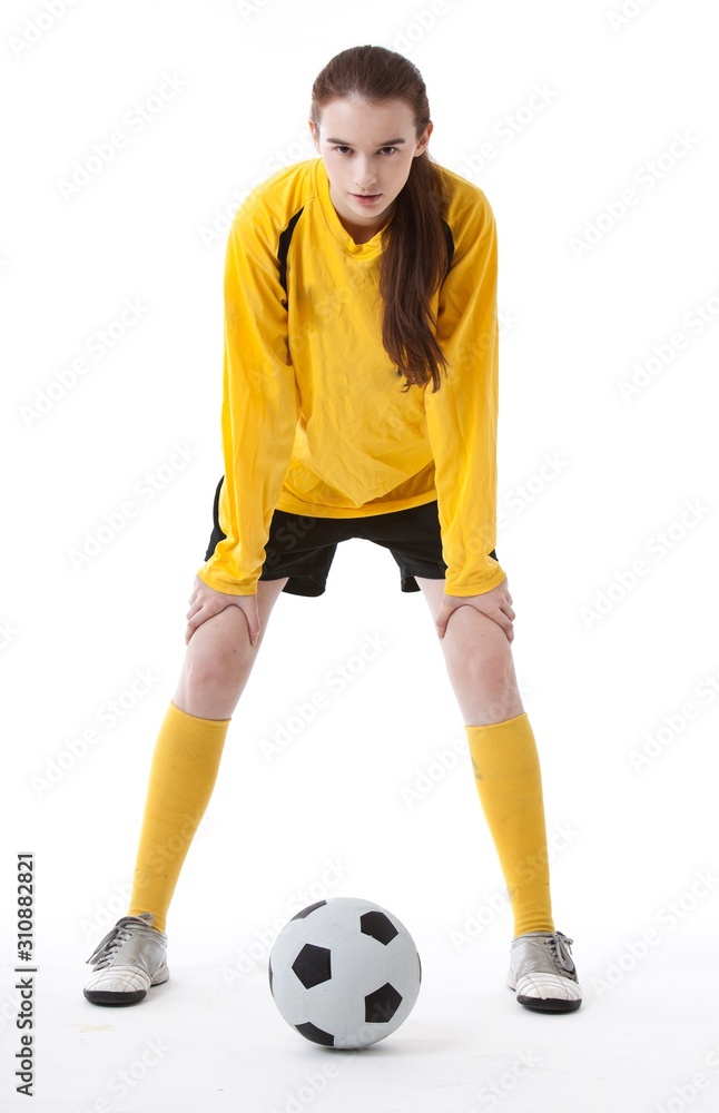 Portrait of young woman with soccer ball against white background