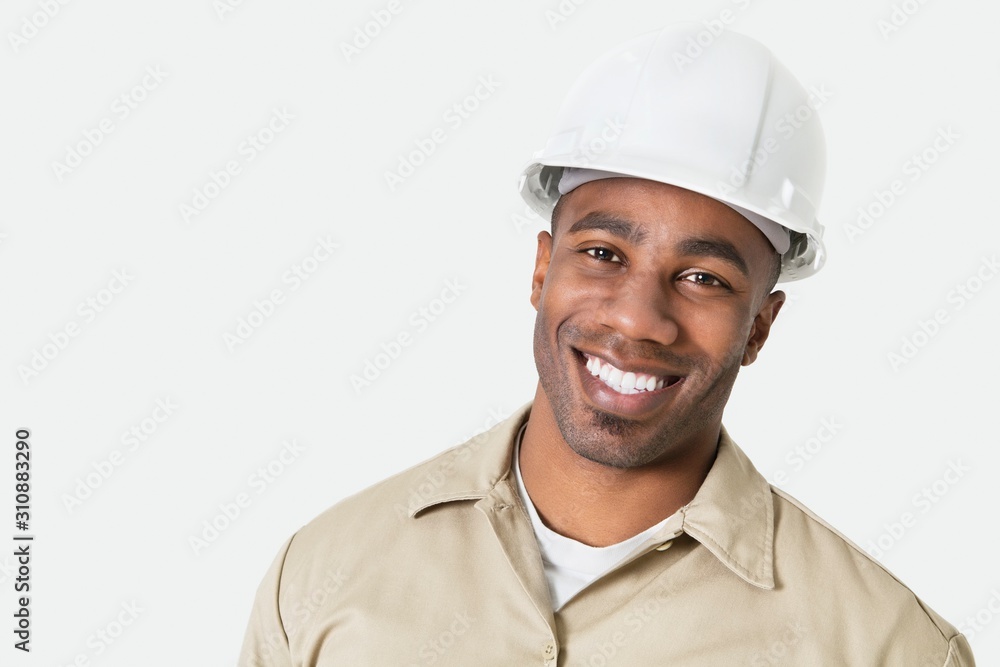 Portrait of happy African construction over with hardhat over gray background Portrait of happy African construction over with hardhat over gray background