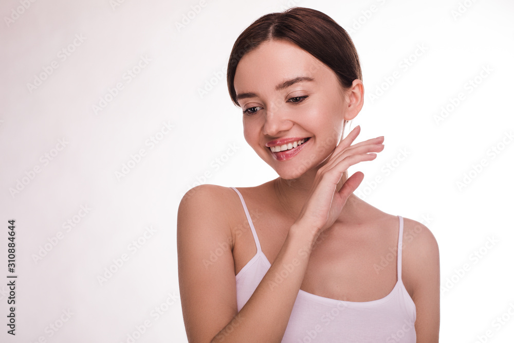 Cheerful beautiful and attractive young woman with clear skin and nice face posing on camera. Look down to left and smile. Wear t-shirt on stripes. Slim well-built professional model. Isolated. Cheerful beautiful and attractive young woman with clear skin and nice face posing on camera. Look down to left and smile. Wear t-shirt on stripes. Slim well-built professional model. Isolated.