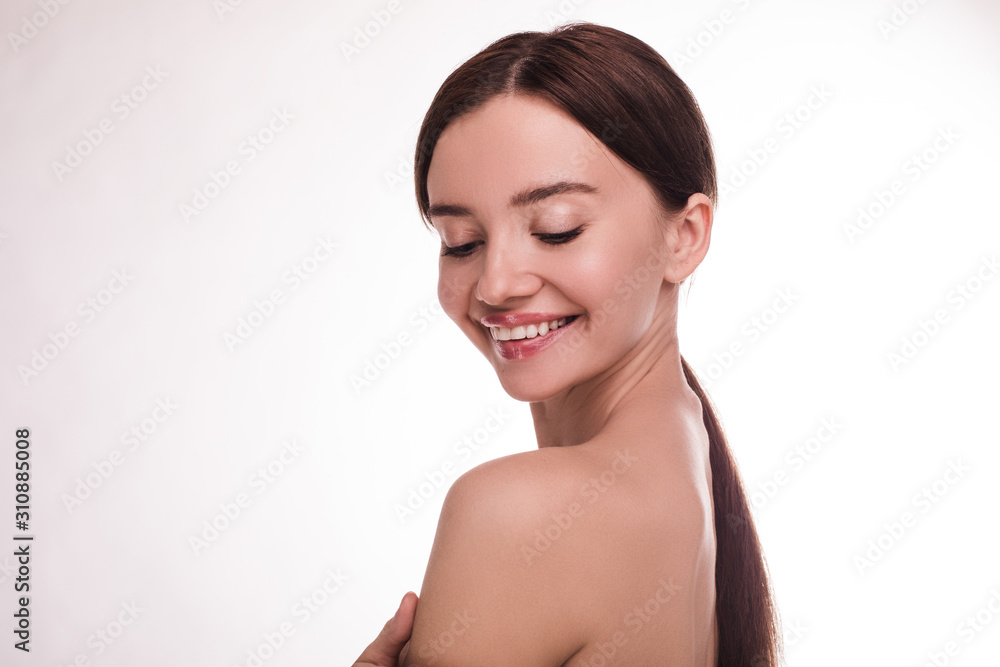 Positive cheerful and attractive young woman smile with eyes closed. Naked in shot. Brunette has beautiful healthy and glowing skin. Slim and thin model isolated over light background. Positive cheerful and attractive young woman smile with eyes closed. Naked in shot. Brunette has beautiful healthy and glowing skin. Slim and thin model isolated over light background.
