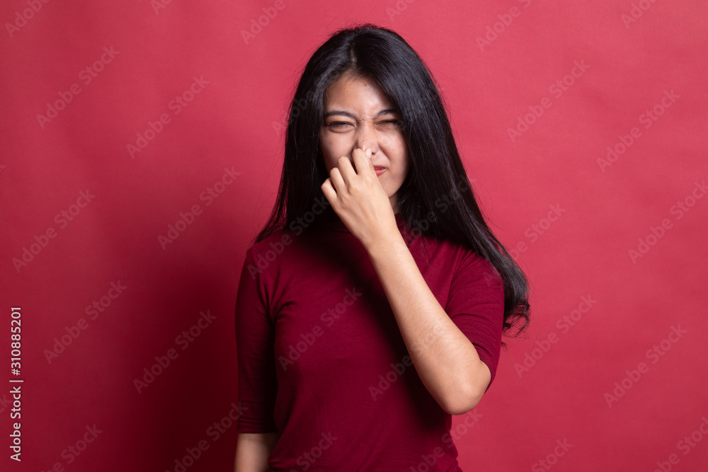 Young Asian woman holding her nose because of a bad smell. Young Asian woman holding her nose because of a bad smell.