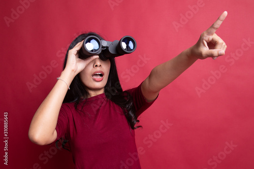 Young Asian woman  point and look with binoculars.