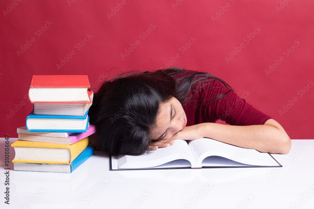 Exhausted Young Asian woman sleep with books on table. Exhausted Young Asian woman sleep with books on table.