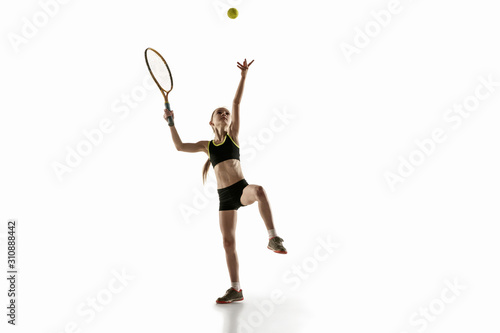 Little caucasian girl playing tennis on white studio background. Cute model training, practicing in motion, action. Youth, flexibility, power and energy. Movement, ad, sport, healthy lifestyle concept © master1305
