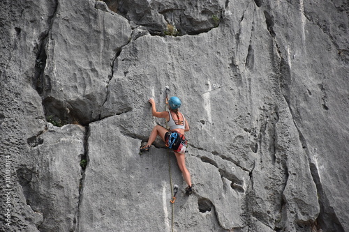 Beautiful girl climbing rock photo