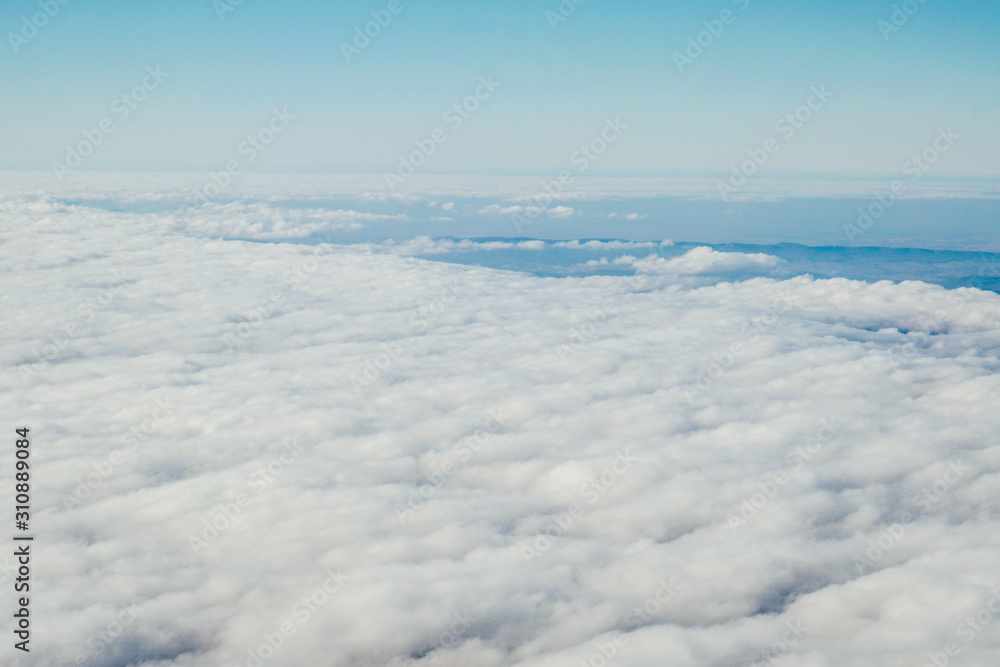 blue sky above white clouds from inside the plane