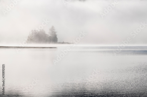 Cold morning fog over beautiful lake in autumn