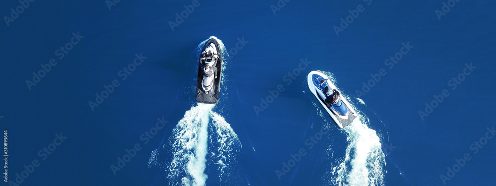 Aerial drone top view of jet skis cruising in deep blue sea Aerial drone top view of jet skis cruising in deep blue sea