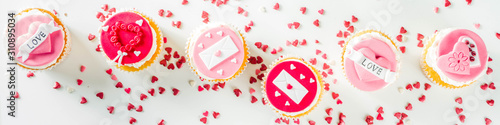 Valentine's day greeting card. Sweet Valentine's creative dessert food. Homemade pink and red  delicious cupcakes with decor of Valentine day symbols