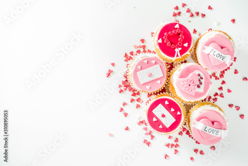 Valentine's day greeting card. Sweet Valentine's creative dessert food. Homemade pink and red delicious cupcakes with decor of Valentine day symbols
