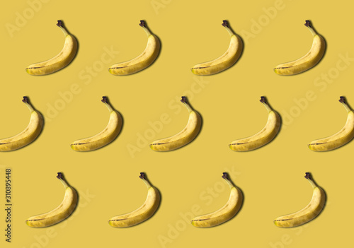 Bananas pattern isolated on yellow background. Summer fruit.