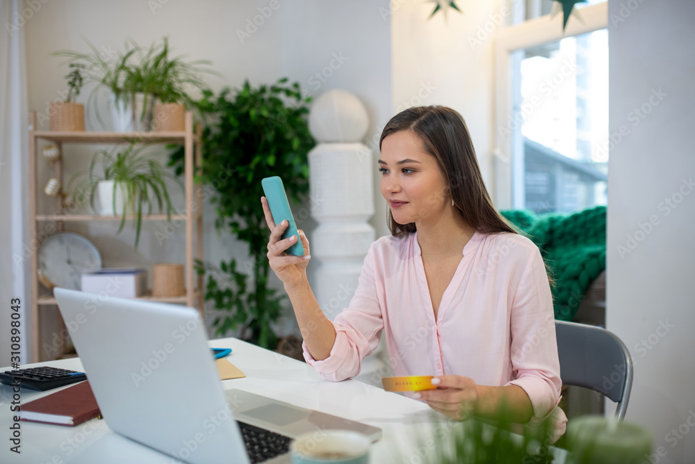 Nice dark haired woman using her smartphone Nice dark haired woman using her smartphone