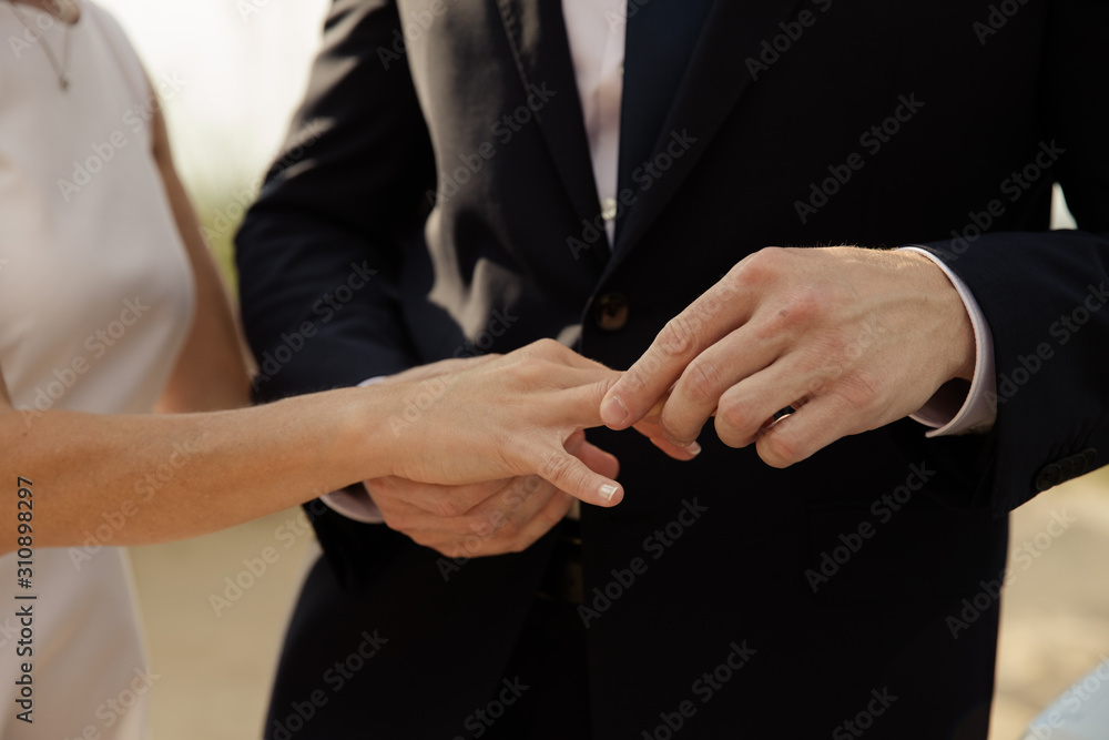 Bräutigam steckt Braut den Ehering an