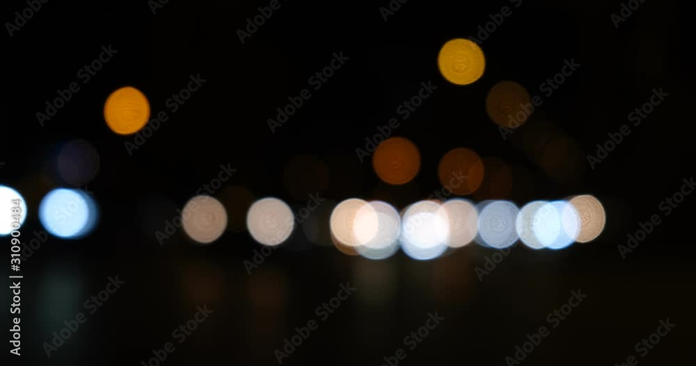 Busy intersection in Lyon, France with out of focus headlights of cars at night, moving fast in a line from right to left. Busy intersection in Lyon, France with out of focus headlights of cars at night, moving fast in a line from right to left.
